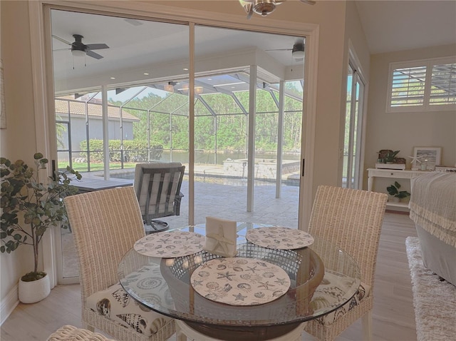 dining room with light wood-style flooring, a sunroom, and ceiling fan