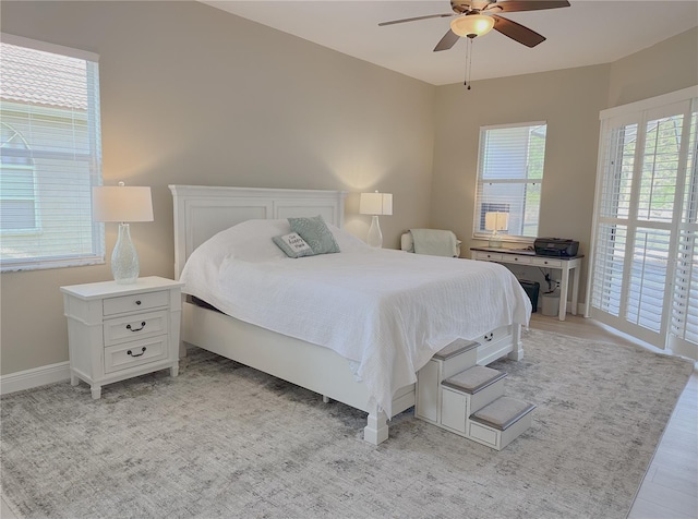 bedroom featuring light wood-style floors, baseboards, and a ceiling fan