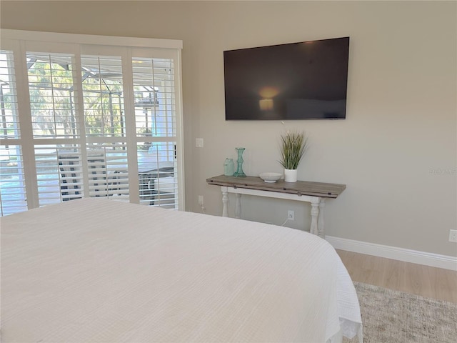 bedroom with wood finished floors and baseboards