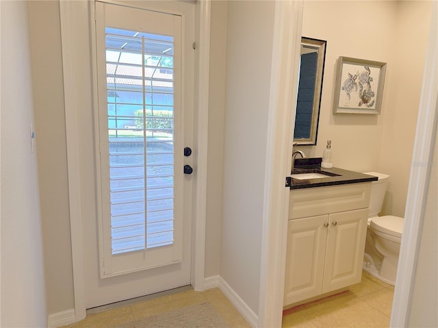 entryway with light tile patterned floors, a sink, and baseboards