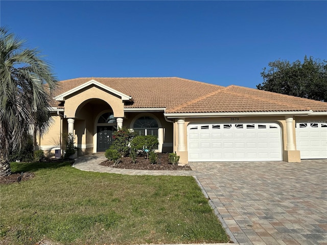 view of front of property featuring a tile roof, an attached garage, decorative driveway, and stucco siding