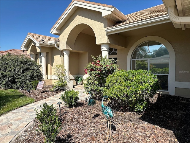 property entrance with a tiled roof and stucco siding