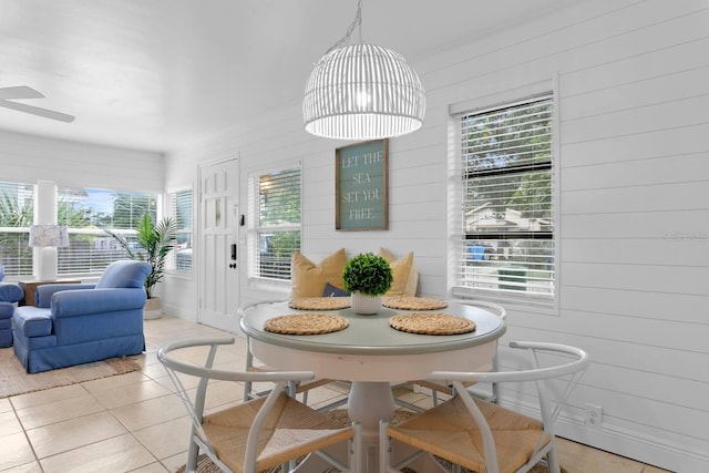 2215 Thrace St, Tampa, FL 33605 - dining area featuring plenty of natural light, light tile patterned flooring, wooden walls, and a ceiling fan
