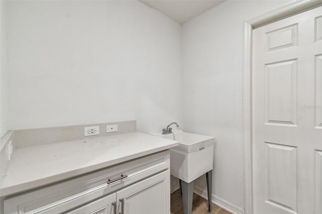 laundry room featuring baseboards and light wood-style flooring