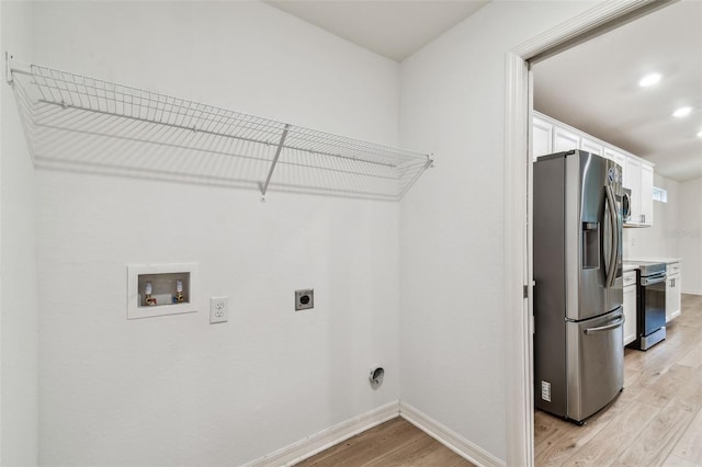 laundry area with baseboards, hookup for a washing machine, light wood-style floors, hookup for an electric dryer, and laundry area