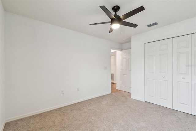 unfurnished bedroom featuring a closet, visible vents, ceiling fan, carpet floors, and baseboards