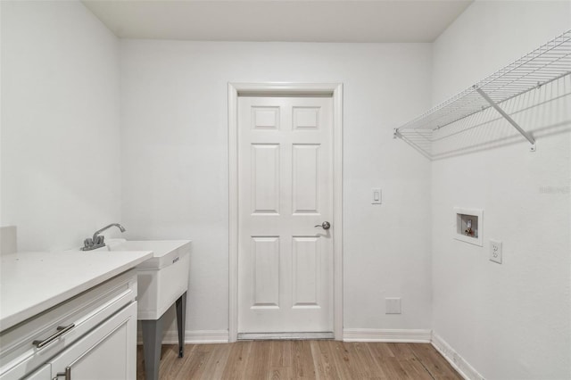 clothes washing area featuring baseboards, light wood-style floors, and hookup for a washing machine