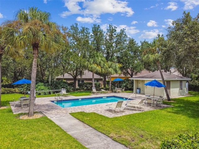 community pool with a patio area and a lawn