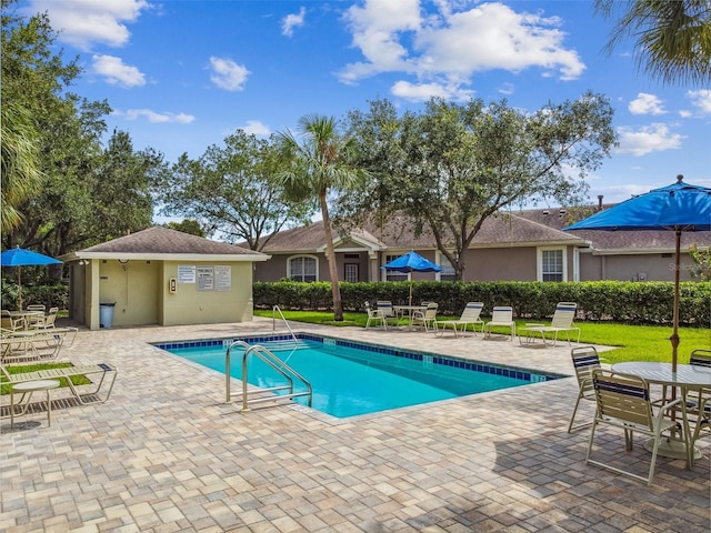 community pool with a patio area and outdoor dining space