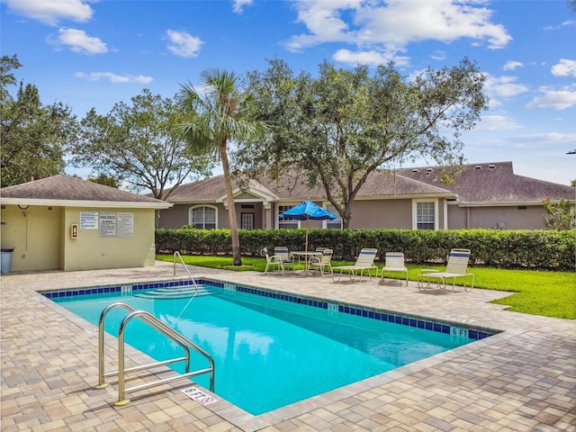 pool featuring a yard and a patio