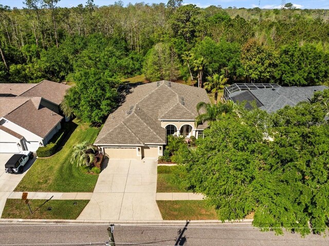 birds eye view of property featuring a view of trees
