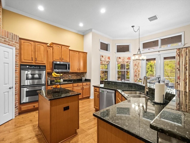 kitchen with crown molding, a spacious island, a sink, and stainless steel appliances