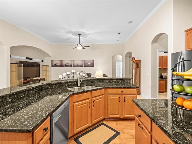 kitchen featuring a sink, arched walkways, crown molding, and stainless steel appliances