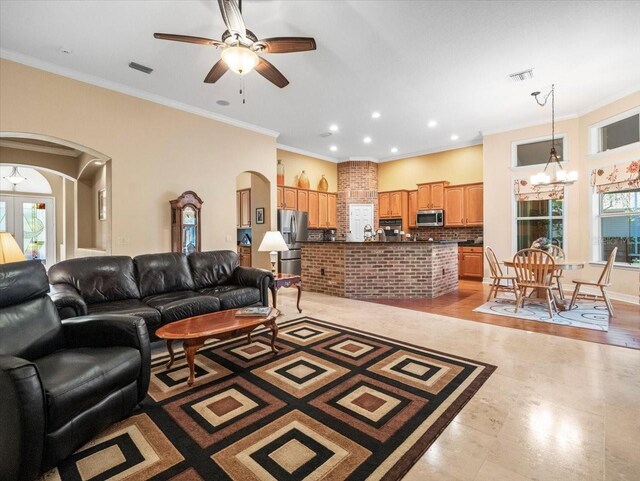 living room with ornamental molding, recessed lighting, visible vents, arched walkways, and ceiling fan with notable chandelier