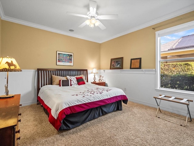 carpeted bedroom with crown molding, baseboards, and a ceiling fan