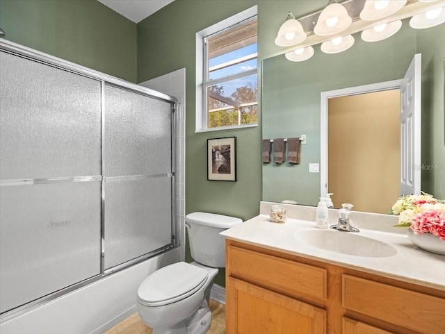 bathroom featuring toilet, enclosed tub / shower combo, and vanity