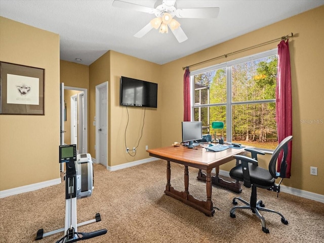 home office featuring baseboards, a ceiling fan, and light colored carpet