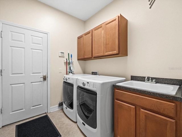 laundry area with a sink, cabinet space, separate washer and dryer, and light tile patterned flooring