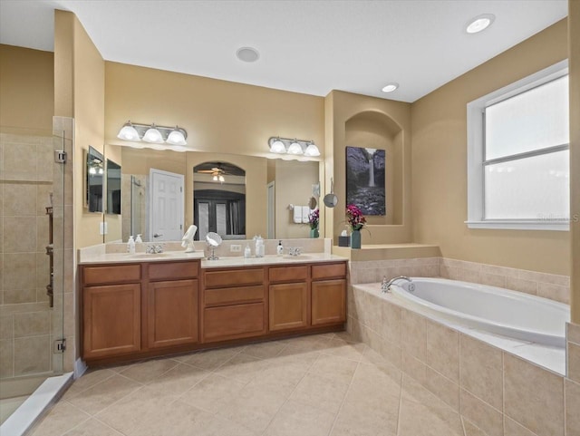 full bath with tile patterned floors, a bath, double vanity, and a stall shower