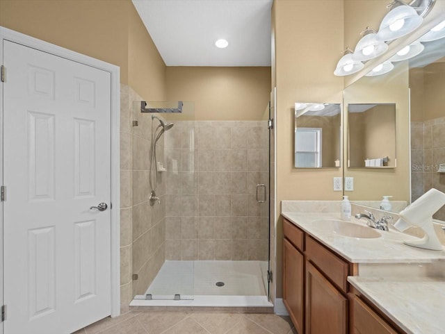 full bathroom featuring tile patterned flooring, a shower stall, and vanity