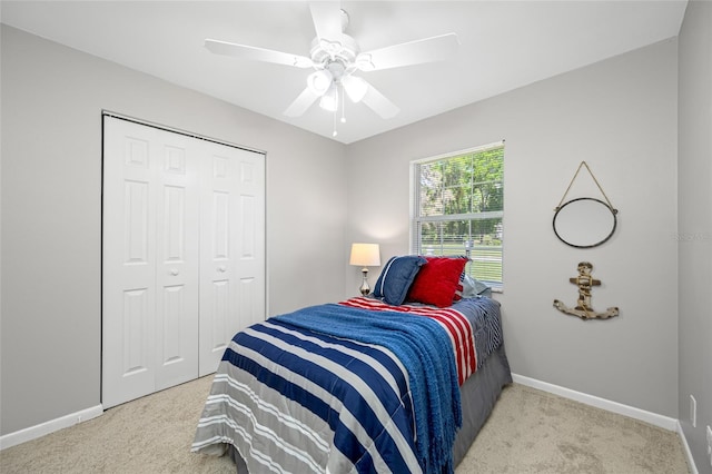 carpeted bedroom with baseboards, ceiling fan, and a closet