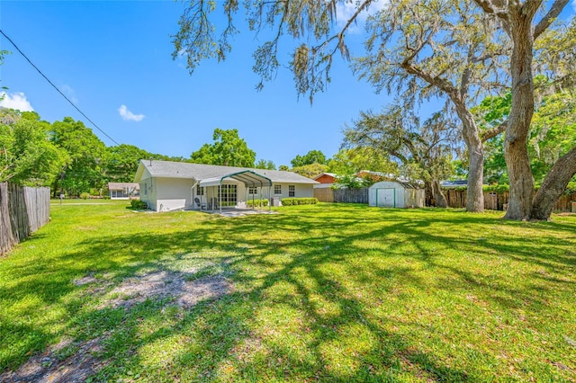 view of yard featuring a storage unit, a fenced backyard, a patio area, and an outdoor structure