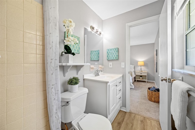 ensuite bathroom featuring vanity, wood finished floors, toilet, ensuite bathroom, and a shower with curtain