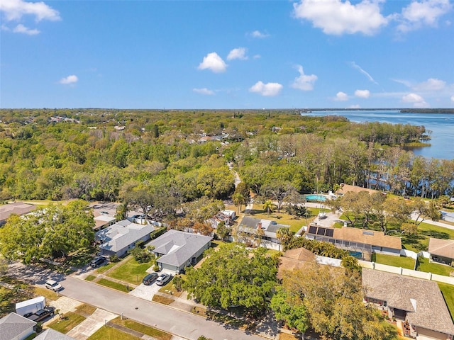 drone / aerial view featuring a forest view, a residential view, and a water view