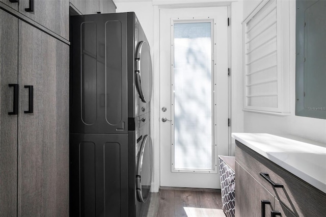 525 Lexington St, Dunedin, FL 34698 - bathroom featuring estacked washer and dryer, wood finished floors, electric panel, and plenty of natural light