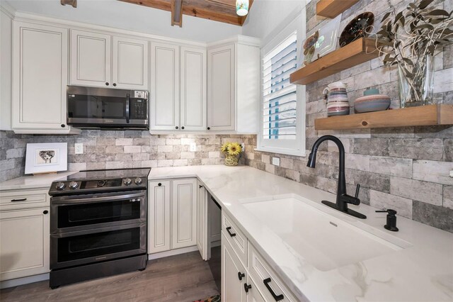 525 Lexington St, Dunedin, FL 34698 - kitchen featuring appliances with stainless steel finishes, a sink, open shelves, backsplash, and white cabinetry