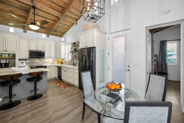 525 Lexington St, Dunedin, FL 34698 - kitchen featuring freestanding refrigerator, wooden ceiling with exposed beams, dishwasher, light countertops, and a sink