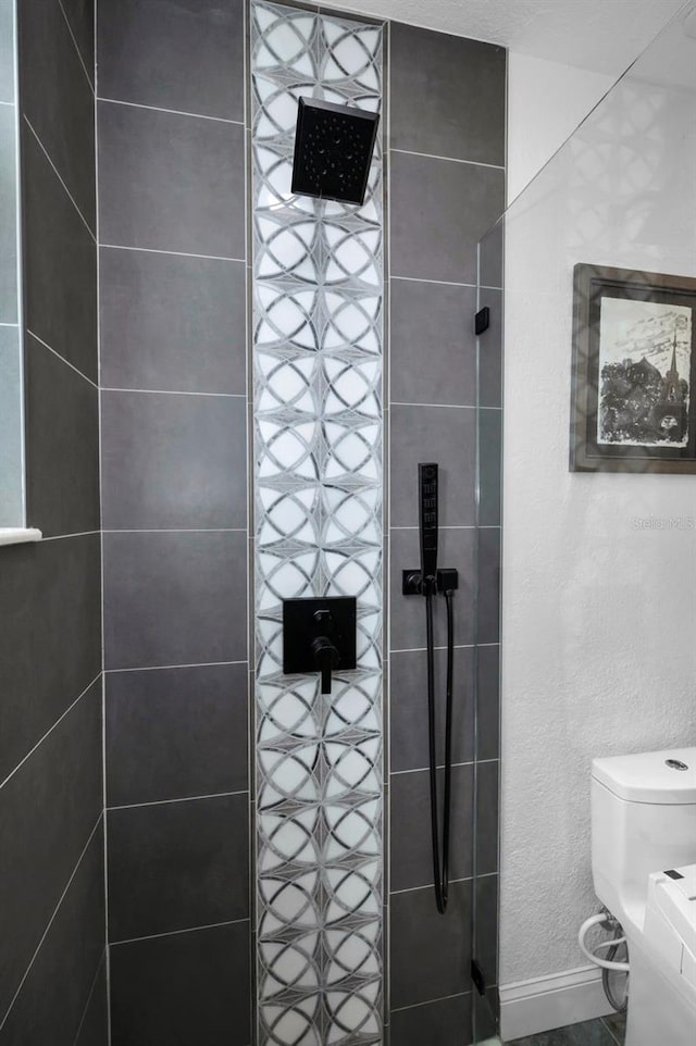 525 Lexington St, Dunedin, FL 34698 - bathroom with tiled shower, toilet, and baseboards