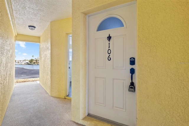 property entrance featuring a water view and stucco siding