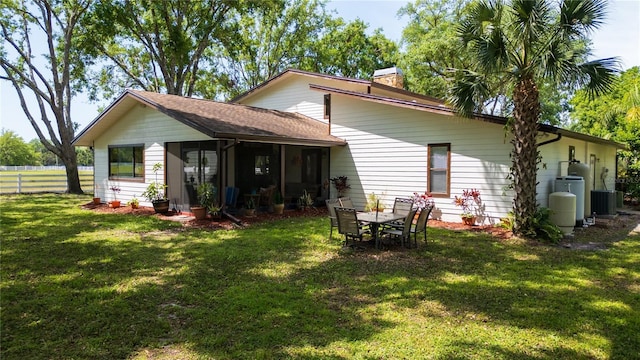 1691 Ridge Top Dr, Tarpon Springs, FL 34688 - back of property with central AC, a chimney, fence, and a lawn