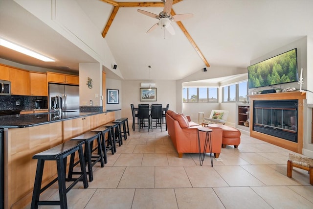 118 94th Ave, Treasure Island, FL 33706 - living room featuring light tile patterned floors, ceiling fan, a glass covered fireplace, and lofted ceiling with beams