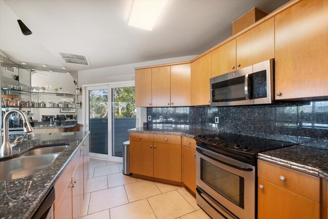 118 94th Ave, Treasure Island, FL 33706 - kitchen with visible vents, a sink, appliances with stainless steel finishes, dark stone counters, and backsplash