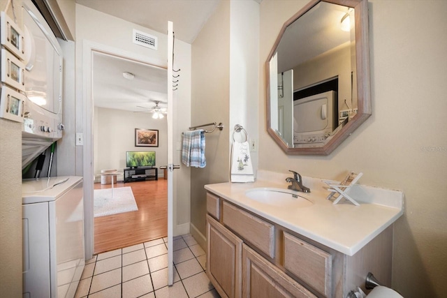 118 94th Ave, Treasure Island, FL 33706 - bathroom featuring vanity, a ceiling fan, visible vents, tile patterned flooring, and stacked washing maching and dryer