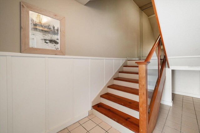 118 94th Ave, Treasure Island, FL 33706 - stairs with tile patterned floors, a decorative wall, and a wainscoted wall