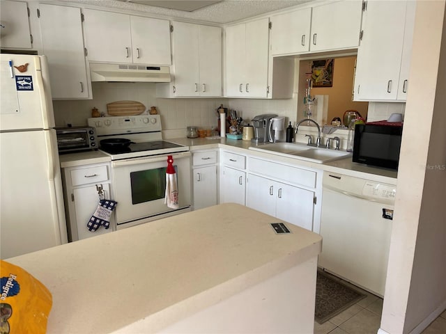 kitchen with white appliances, under cabinet range hood, light countertops, a sink, and a toaster