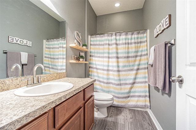 bathroom with toilet, a shower with curtain, vanity, and wood finished floors