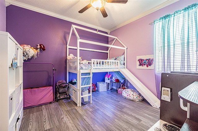 bedroom featuring crown molding, wood finished floors, and ceiling fan