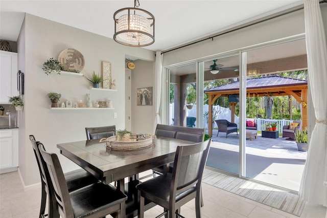 dining room featuring light tile patterned floors and ceiling fan with notable chandelier