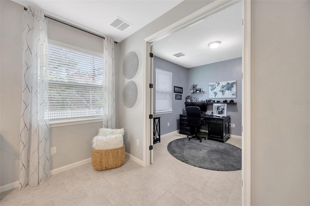 office space with baseboards and visible vents