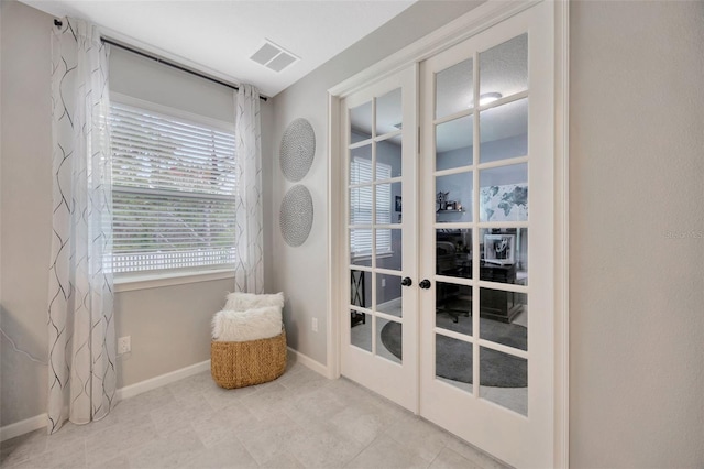 doorway to outside featuring baseboards, french doors, and visible vents