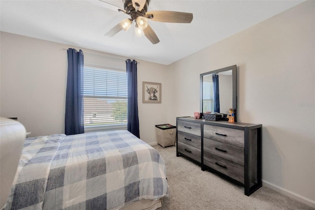 bedroom featuring baseboards, ceiling fan, and light carpet