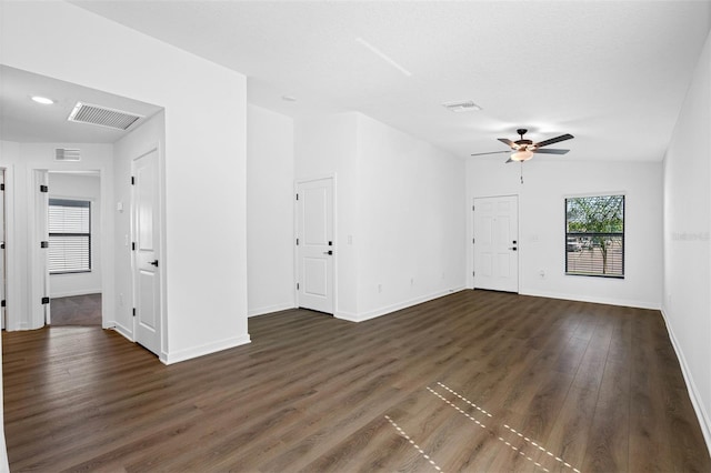 unfurnished living room with dark wood-style flooring, a ceiling fan, and visible vents