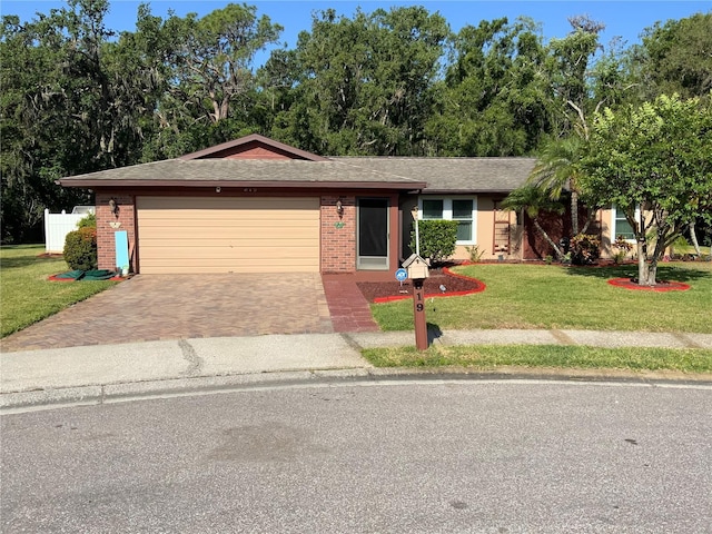 819 Satinleaf Ave, Oldsmar, FL 34677 - ranch-style house featuring decorative driveway, brick siding, a front lawn, and a garage