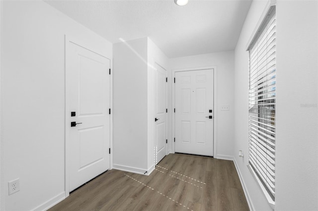 doorway with baseboards and wood finished floors