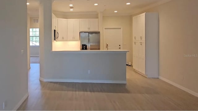 kitchen featuring a peninsula, baseboards, recessed lighting, white cabinets, and appliances with stainless steel finishes