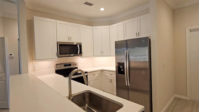 kitchen featuring light countertops, stainless steel appliances, visible vents, and white cabinetry